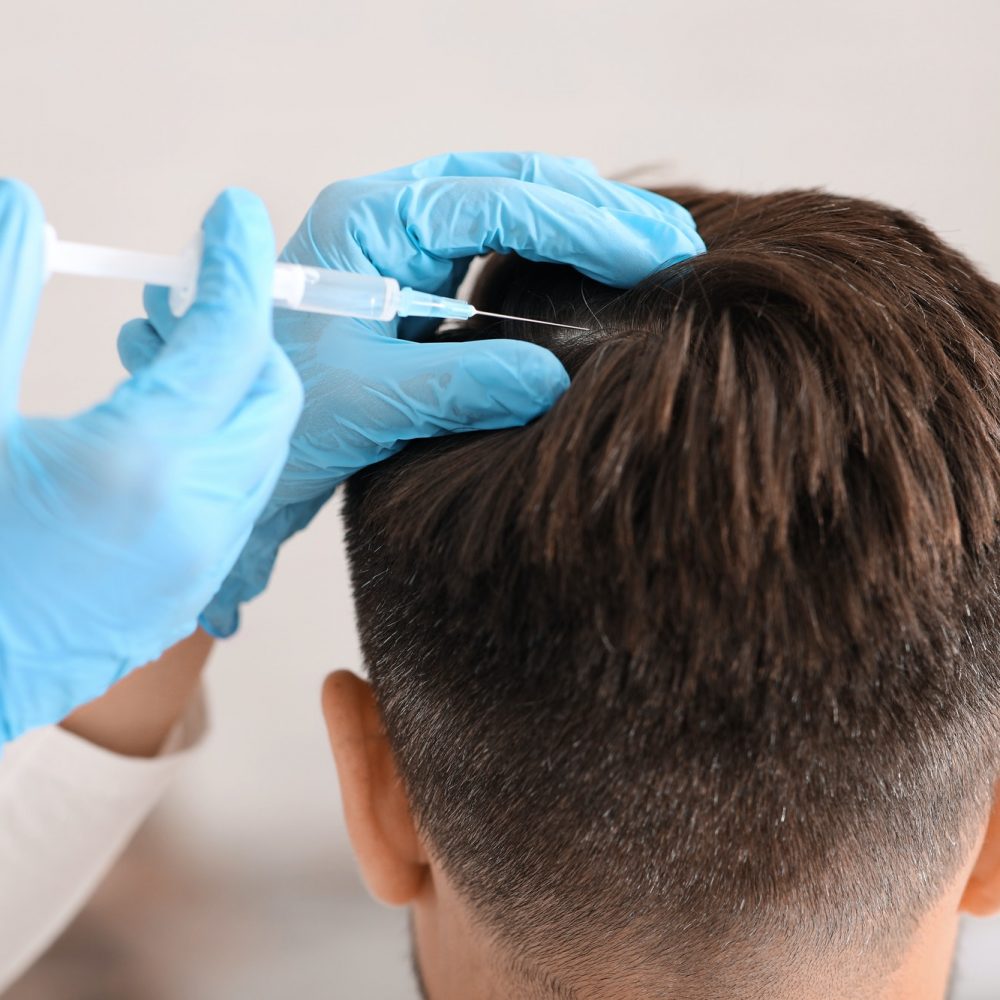 Unrecognizable man having hair treatment at beauty salon